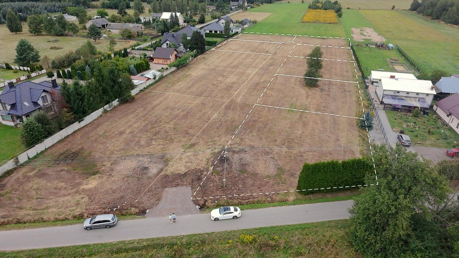 Zdjęcie z drona dziś: puste działki przy ul. Podłaziska z zaznaczonymi granicami.